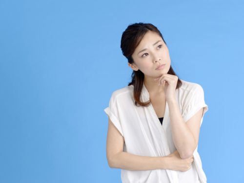 首をかしげる女性